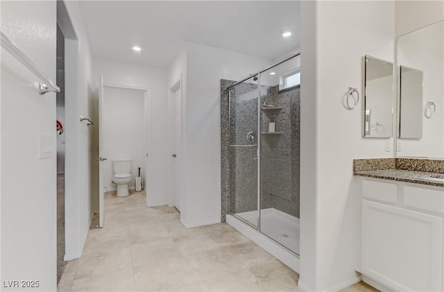 bathroom with vanity, a shower with door, and toilet