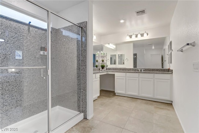 bathroom with walk in shower, vanity, and tile patterned flooring