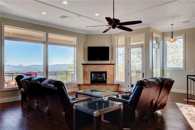 living room featuring crown molding, dark hardwood / wood-style flooring, a high end fireplace, and a wealth of natural light