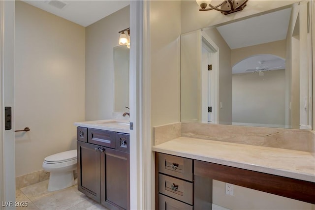 bathroom with tile patterned flooring, vanity, ceiling fan, and toilet