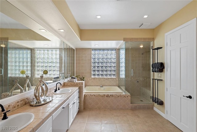 bathroom featuring tile patterned flooring, vanity, and shower with separate bathtub