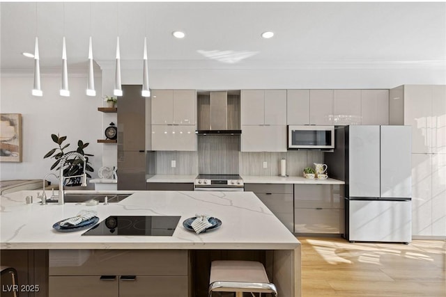 kitchen featuring wall chimney range hood, appliances with stainless steel finishes, and gray cabinetry