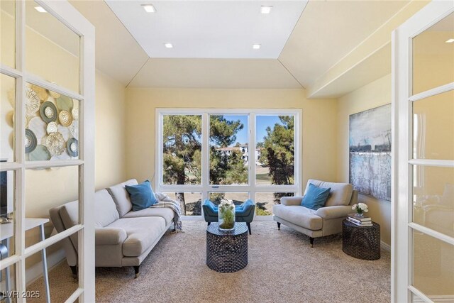 sitting room with vaulted ceiling, carpet floors, and french doors