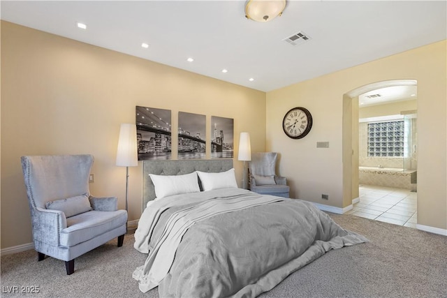 carpeted bedroom featuring baseboards, visible vents, arched walkways, tile patterned flooring, and recessed lighting