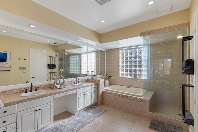 bathroom featuring a garden tub, a stall shower, a sink, and tile patterned floors