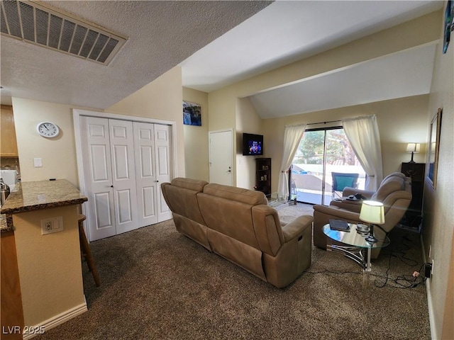 carpeted living room featuring vaulted ceiling and a textured ceiling