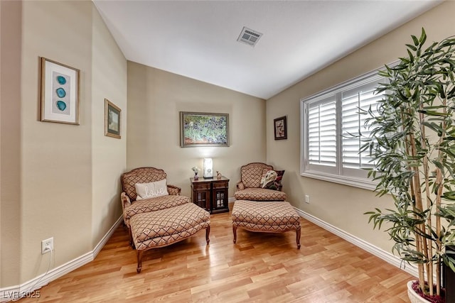 sitting room with vaulted ceiling and light wood-type flooring