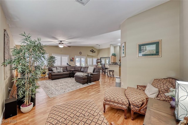 living room with vaulted ceiling, light hardwood / wood-style floors, and ceiling fan