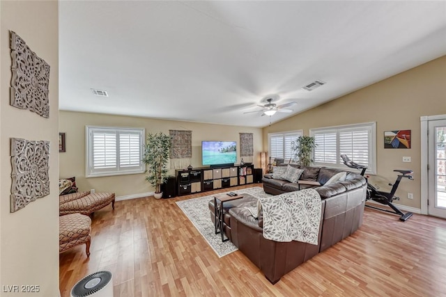 living room featuring lofted ceiling, ceiling fan, light hardwood / wood-style flooring, and a healthy amount of sunlight