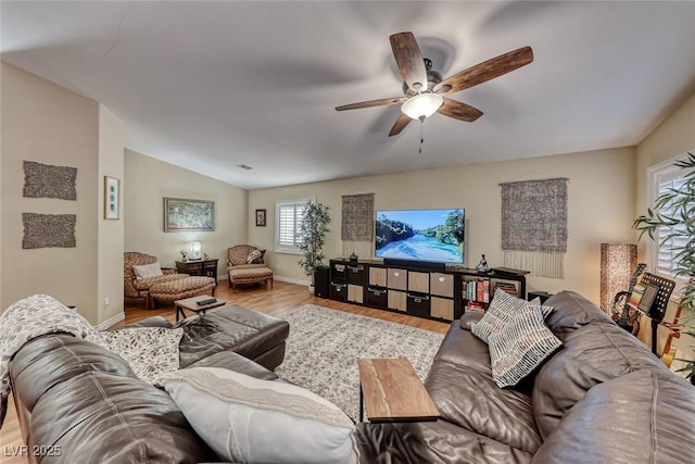 living room featuring hardwood / wood-style flooring, vaulted ceiling, and ceiling fan