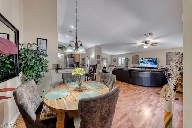 dining room featuring ceiling fan, lofted ceiling, and light wood-type flooring