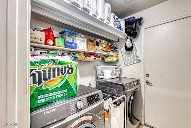 clothes washing area with washing machine and dryer and a textured ceiling