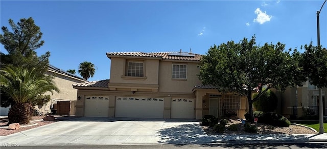 mediterranean / spanish-style house with a garage and solar panels