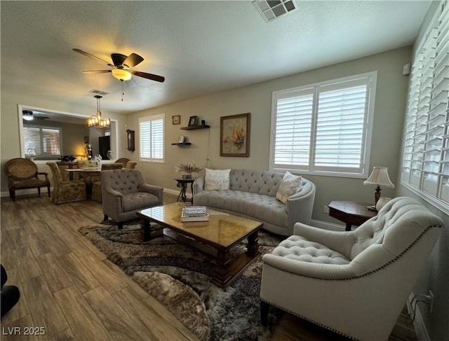 living room with hardwood / wood-style flooring, a textured ceiling, and ceiling fan