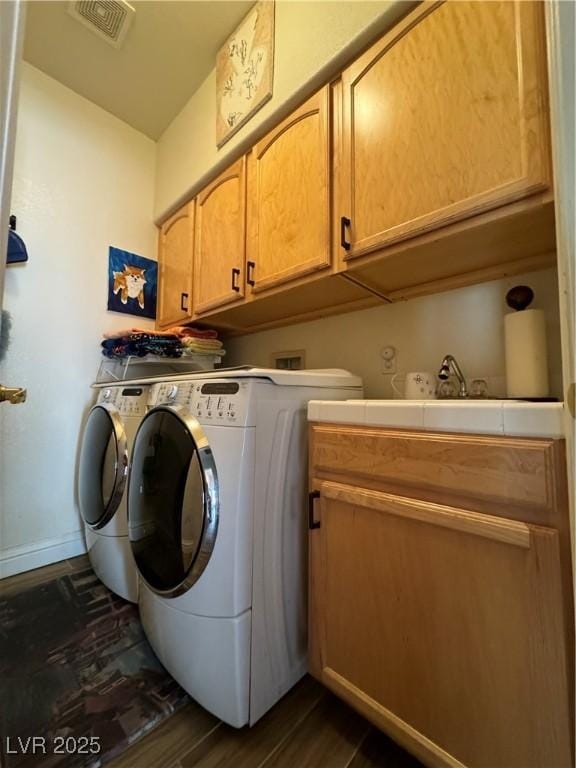 clothes washing area with independent washer and dryer, cabinets, dark hardwood / wood-style flooring, and sink