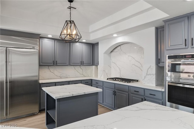 kitchen featuring gray cabinetry, appliances with stainless steel finishes, a center island, open shelves, and pendant lighting