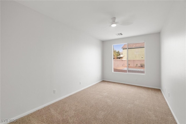 unfurnished room with carpet flooring, visible vents, ceiling fan, and baseboards