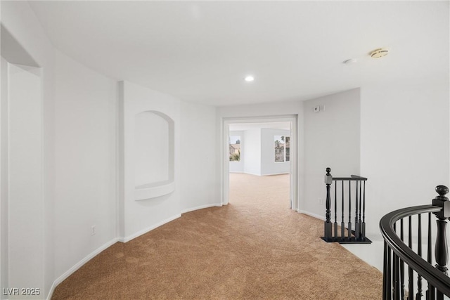 corridor with light carpet, recessed lighting, baseboards, and an upstairs landing