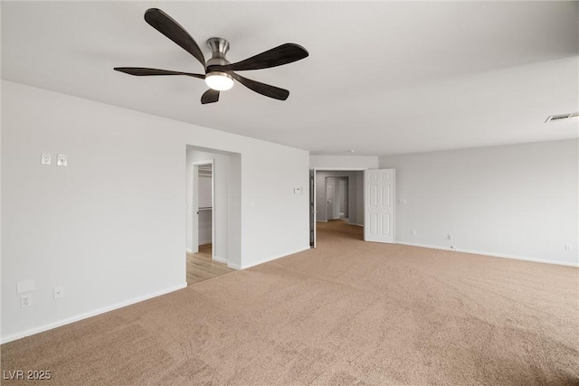 empty room featuring baseboards, a ceiling fan, visible vents, and light colored carpet