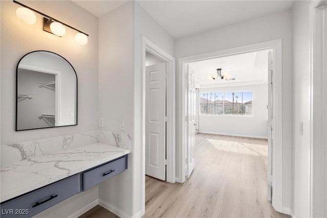 bathroom with vanity, baseboards, and wood finished floors