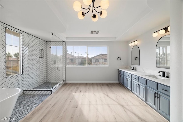 full bathroom featuring a sink, visible vents, a freestanding bath, double vanity, and a stall shower