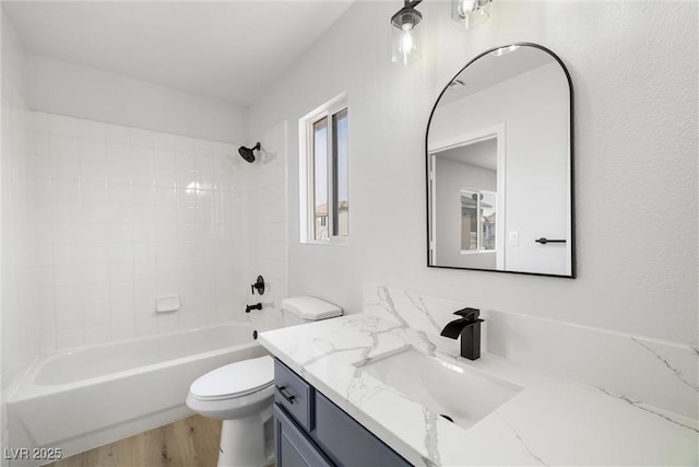 full bath with toilet, wood finished floors, bathtub / shower combination, and vanity