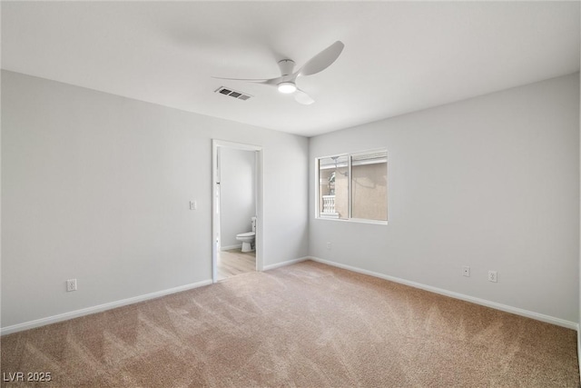 empty room with a ceiling fan, light colored carpet, visible vents, and baseboards