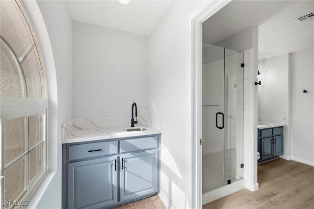 full bath featuring visible vents, a stall shower, wood finished floors, and vanity