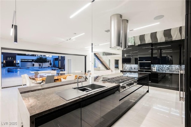 kitchen featuring sink, hanging light fixtures, stainless steel gas cooktop, a kitchen island, and oven