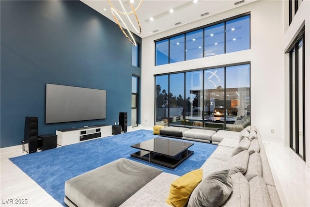 living room with a towering ceiling and light wood-type flooring