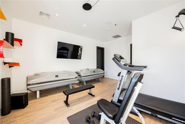 exercise room with light hardwood / wood-style floors