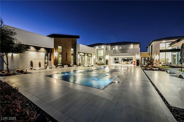 pool at night with a patio area