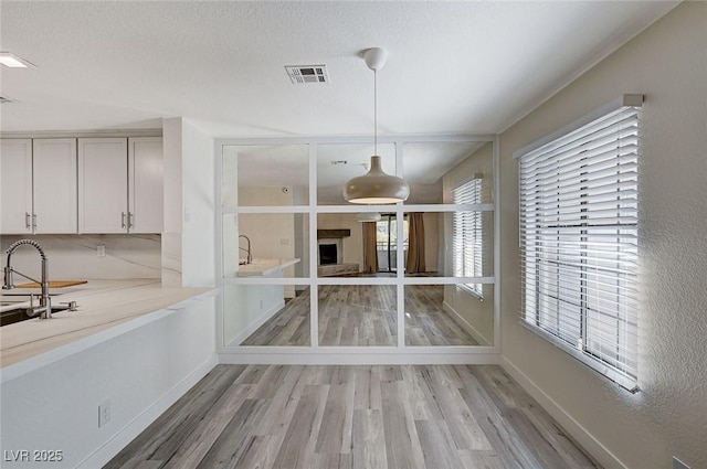 unfurnished dining area featuring light hardwood / wood-style flooring and a textured ceiling