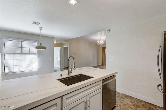 kitchen with sink, white cabinetry, stainless steel refrigerator, black dishwasher, and pendant lighting