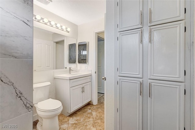 bathroom with vanity, tile patterned floors, and toilet