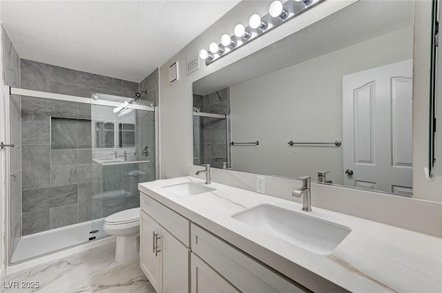 bathroom featuring walk in shower, vanity, and toilet