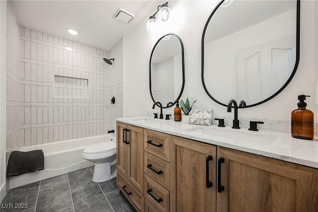 full bathroom featuring tiled shower / bath, vanity, and toilet