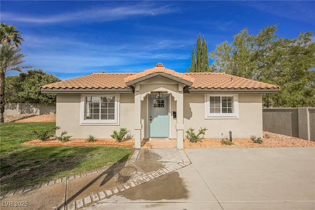 mediterranean / spanish-style home with a front yard