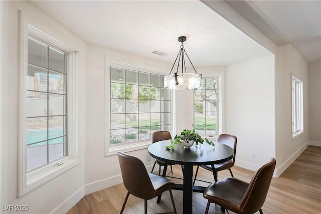 dining area with a notable chandelier and light wood-type flooring