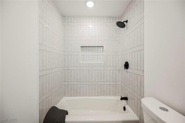 bathroom featuring toilet and tiled shower / bath combo