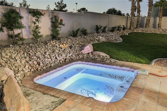 view of swimming pool with a yard and a jacuzzi