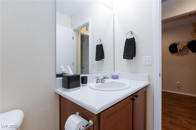 bathroom with vanity, wood-type flooring, and toilet