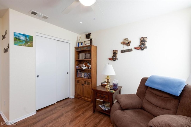 sitting room featuring wood-type flooring and ceiling fan