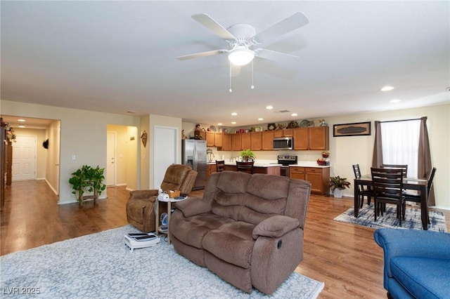 living room with ceiling fan and light wood-type flooring