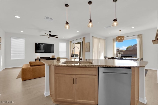 kitchen with decorative light fixtures, dishwasher, an island with sink, sink, and light hardwood / wood-style flooring