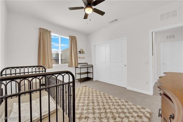 carpeted bedroom with ceiling fan and a closet