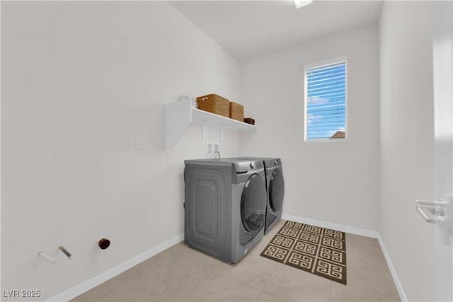 clothes washing area with light tile patterned floors and washer and dryer