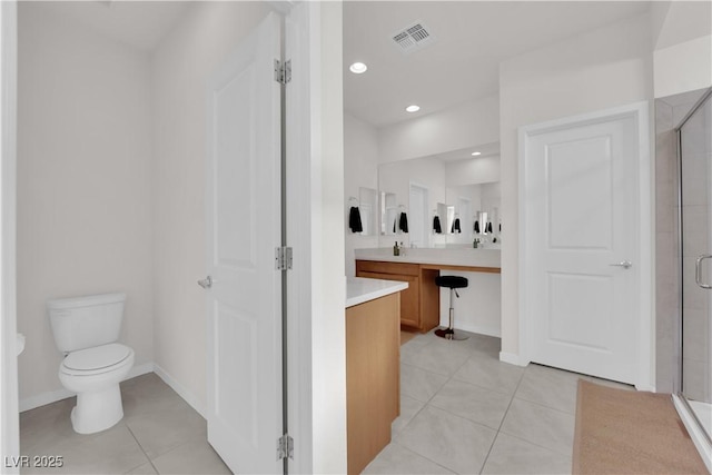 bathroom featuring a shower with door, vanity, tile patterned floors, and toilet