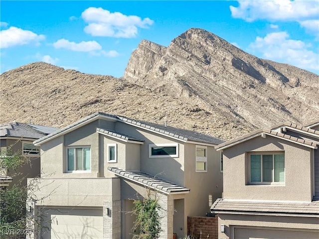 view of front of home with a garage and a mountain view