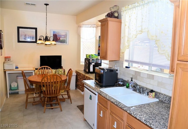 kitchen with sink, hanging light fixtures, white dishwasher, tasteful backsplash, and a wealth of natural light